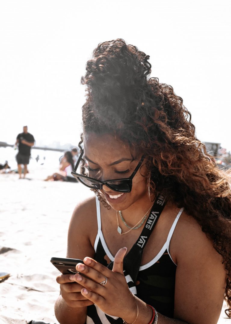 woman using phone on beach